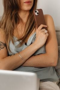 Kaboompics - Close-Up of a Woman Holding a Brown Smartphone in Satin Loungewear