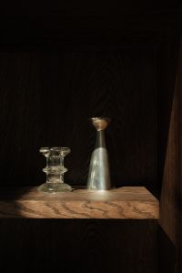 Kaboompics - Glass Candle Holder and Silver Vase on a Moody Dark Wood Shelf