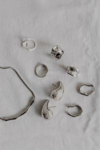 Kaboompics - Assorted Silver Jewelry and Chain on White Fabric