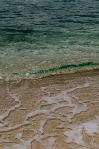 Kaboompics - Turquoise Shore Break With Foamy Patterns On Sand