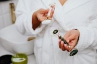 Kaboompics - Close-Up of Hands Holding Jade Facial Rollers During a Home Skincare Routine