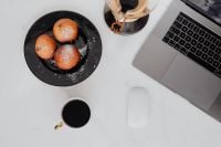 Kaboompics - Marble desk with laptop, homemade Polish doughnuts and coffee