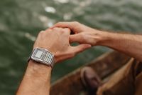 Kaboompics - Close Crop of Interlaced Hands and Retro Digital Calculator Watch, Lake in Background