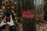 Kaboompics - The woman takes a picture of the sign on the tree