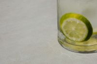 Kaboompics - Lime Slice Inside a Clear Glass on Pale Marble, Close-Up Summer Drink Background with Copy Space