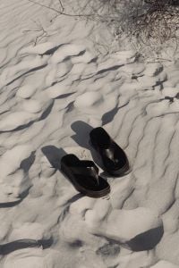 Kaboompics - Black Sandals on Wind-Rippled Beach Sand