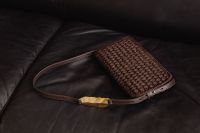 Kaboompics - Woven Brown Handbag on a Black Leather Sofa