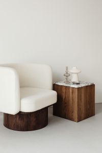 Kaboompics - Neutral Armchair and Wooden Side Table with Sculptural Decor