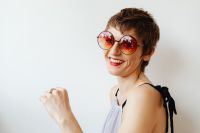 Kaboompics - Smiling Woman in Red Sunglasses with Rainbow Neck Paint