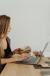 Kaboompics - Woman Holding Material Samples Beside Laptop
