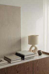 Kaboompics - Japandi Sideboard Styling with Ceramic Lamp, Wall Art and Stacked Books