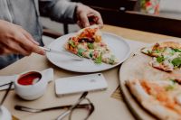 Kaboompics - Hand Lifting a Slice from a Freshly Baked Pizza