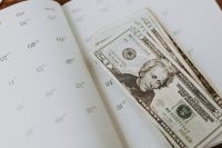 Kaboompics - US Dollar Bills Spread across an Open Calendar, Monthly Budget Planning