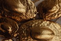 Kaboompics - Close-Up of Hammered Gold Pendant Discs on a Dark Background