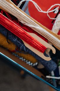 Kaboompics - Red, Blue and Mustard Yarn on Weaving Tools
