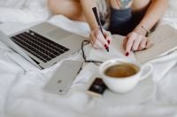 Kaboompics - Woman working on a laptop while enjoying a breakfast coffee and chocolate in bed