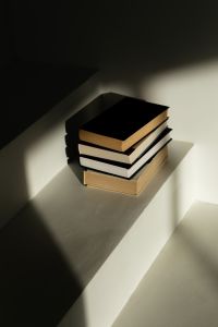 Kaboompics - Dramatic Light and Shadow on Stack of Books in Minimalist Interior