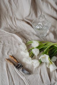Kaboompics - White Tulips and Pruning Shears with a Textured Vase, Floral Styling on Linen