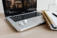 Kaboompics - Close-Up of Laptop with AirPods and Notebook