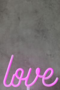 Kaboompics - Pink Neon Love Sign on Gray Wall With Tabletop