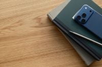 Kaboompics - Smartphone on Notebook Stack on Wooden Table