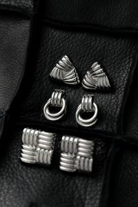 Kaboompics - Silver Statement Earrings on Black Leather