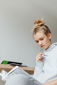 Kaboompics - Student Reading Textbook at Desk