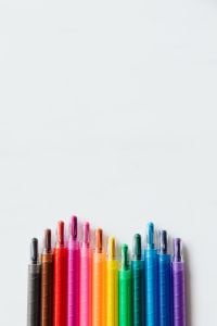 Kaboompics - Rainbow Crayons Along the Bottom of a White Background with Copy Space for School Design