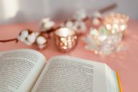 Kaboompics - Open Book and Soft Candlelight in a Pink Reading Scene