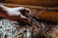 Kaboompics - Man grabbing a heap of rusty nails