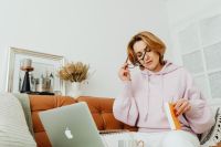Kaboompics - Middle-Aged Woman Taking a Phone Call While Holding a Notebook at Home