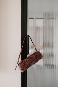Kaboompics - Burgundy Woven Shoulder Bag Hanging on Glass Door