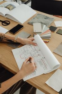 Kaboompics - Hands Drawing on Floor Plan With Material Samples