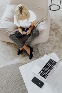 Work from Home Lifestyle: Woman on Sofa with Laptop and Phone