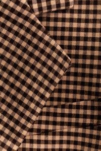 Kaboompics - Brown and Black Gingham Fabric Folded into Layered Diagonal Drapes, Check Pattern Textile Background for Fashion