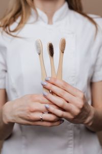 Kaboompics - Three Bamboo Toothbrushes in Front of a Dentist’s White Coat, Oral Hygiene Product Styling
