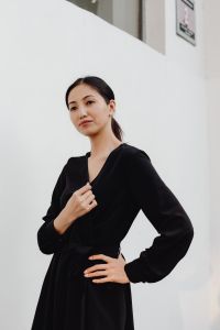 Kaboompics - Asian Woman with Hair Tied Back in Black Dress and Minimal White Background