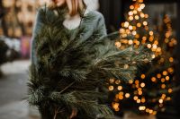 Kaboompics - The woman is holding pine branches in her hands