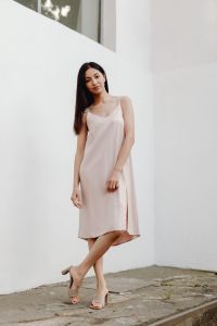 Kaboompics - Full Body Woman in Pale Dress Crossing Her Legs beside White Wall