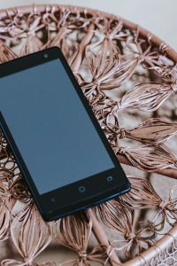 Black smartphone on a miniature brown table