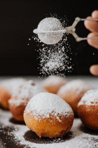 Kaboompics - Powdered Sugar Falling onto One Pączek on a Dark Background