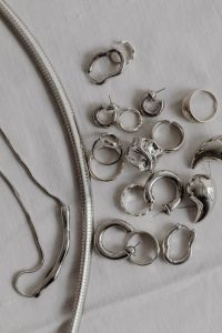 Kaboompics - Silver Necklace and Jewelry on White Fabric