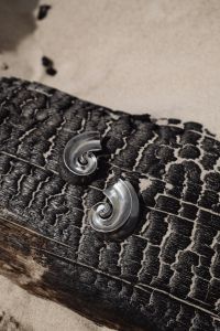 Kaboompics - Silver Spiral Earrings on Textured Driftwood