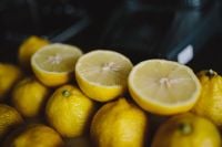 Kaboompics - Fresh Lemon Halves and Whole Citrus in a Dark Still Life, Close-Up Food Photography with Shallow Focus