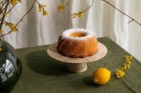 Kaboompics - Powdered Bundt Cake on a Stone Stand with Lemon and Spring Branches