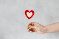 Kaboompics - Hand Holding Red Heart Lollipop on Gray Background