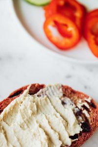 Kaboompics - Close-Up Hummus Toast with Blurred Red Pepper Plate