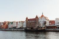 Kaboompics - Gdańsk Old Town Waterfront with Historic Black Sailing Ship and Colorful Townhouses