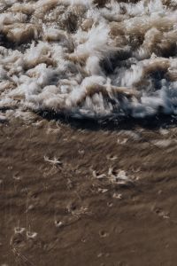 Kaboompics - Vertical Surf Breaking onto Dark Sand, Coastal Water Texture