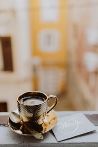Kaboompics - Drink coffee in a golden cup at the window